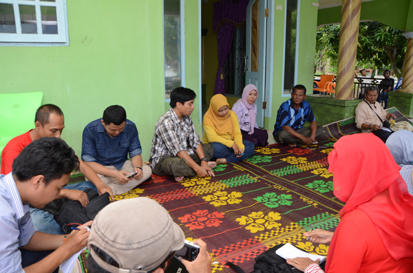 Sumatra and Kalimantan reporters cover Riau after the wildfires Photo caption: Workshop participants meet Tanjungleban Village Head Haji Atim (blue striped shirt second from right facing camera) on the front veranda of his house June 1 2014. (*)